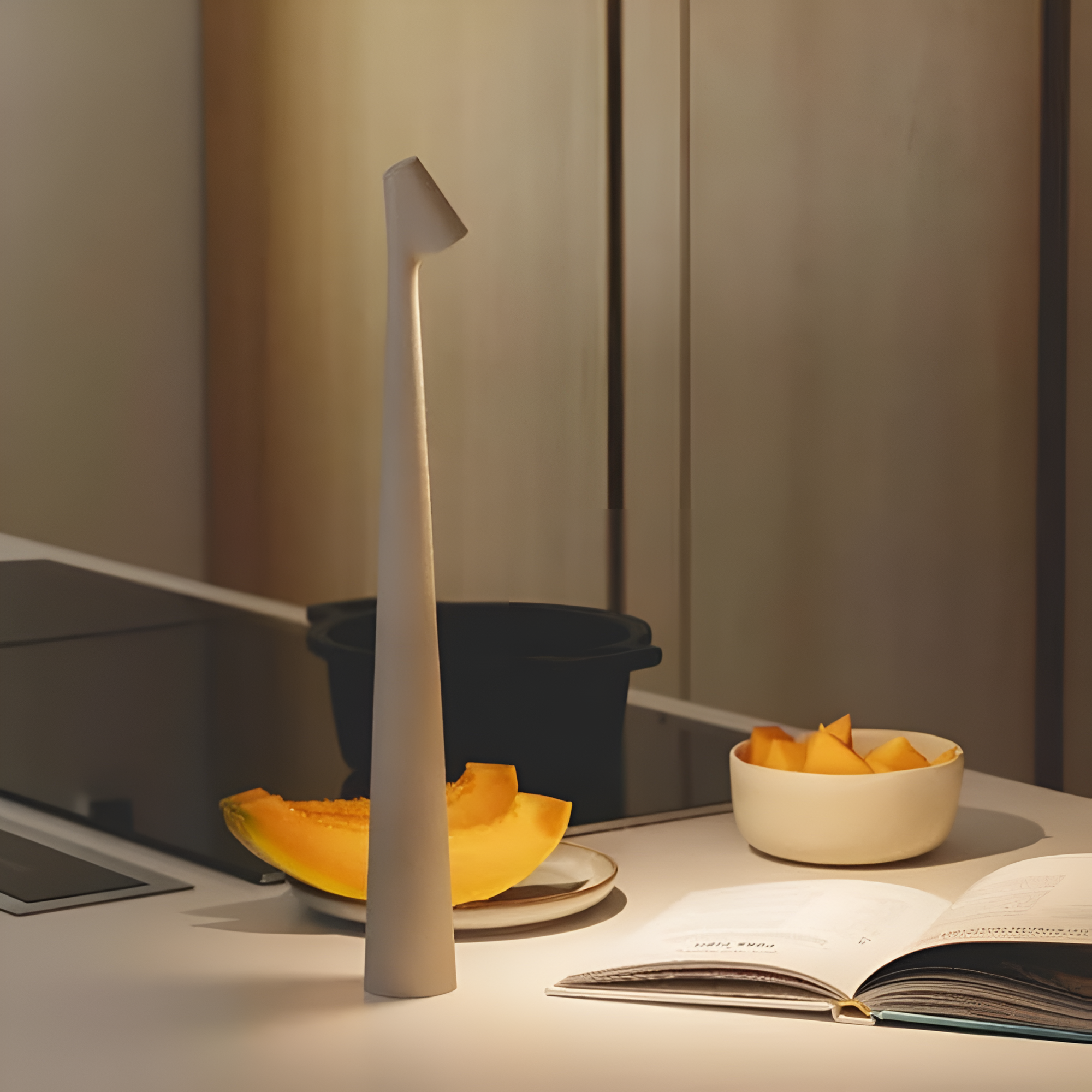Desk with a lamp, fruit, and open book in a dimly lit room