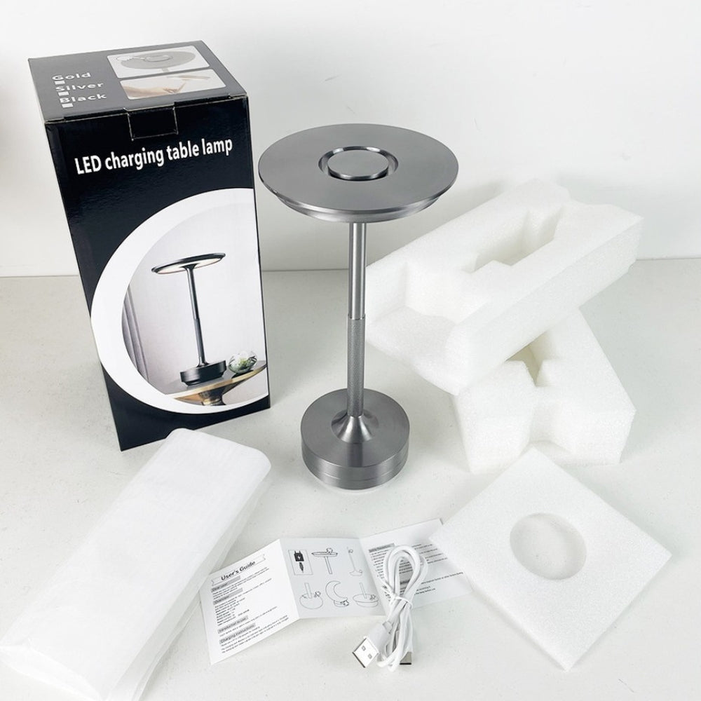 LED charging table lamp with packaging, cable, and user manual on a white surface