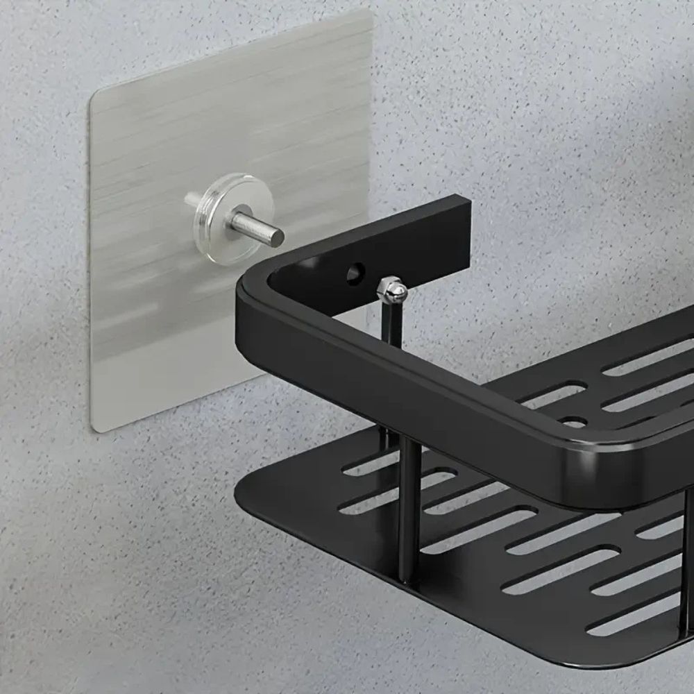 Black metal wall-mounted shower caddy on a gray wall