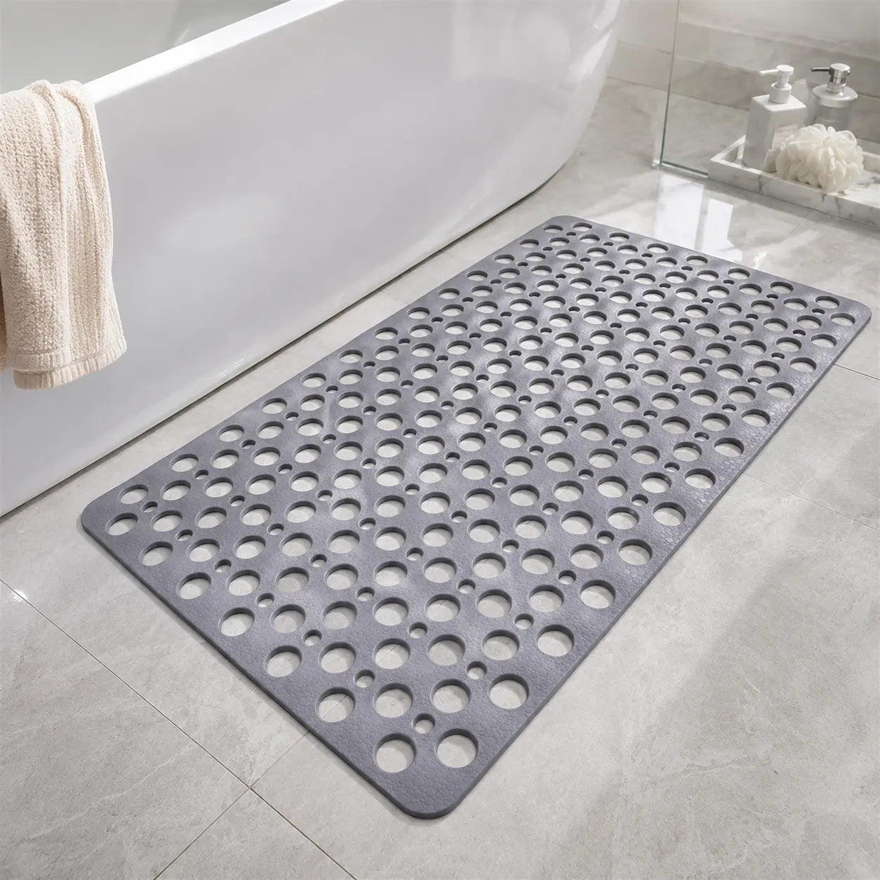 Gray bath mat with circular holes on a bathroom floor