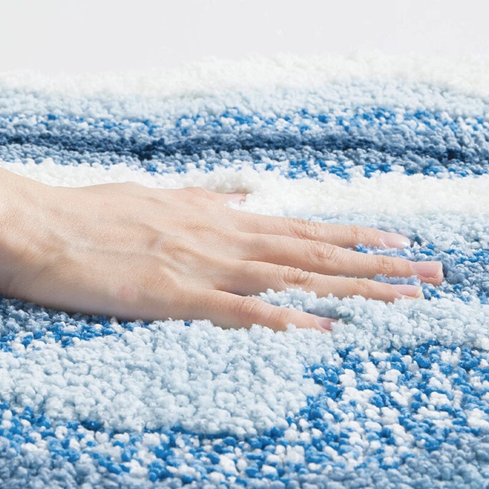Hand touching a blue and white striped carpet