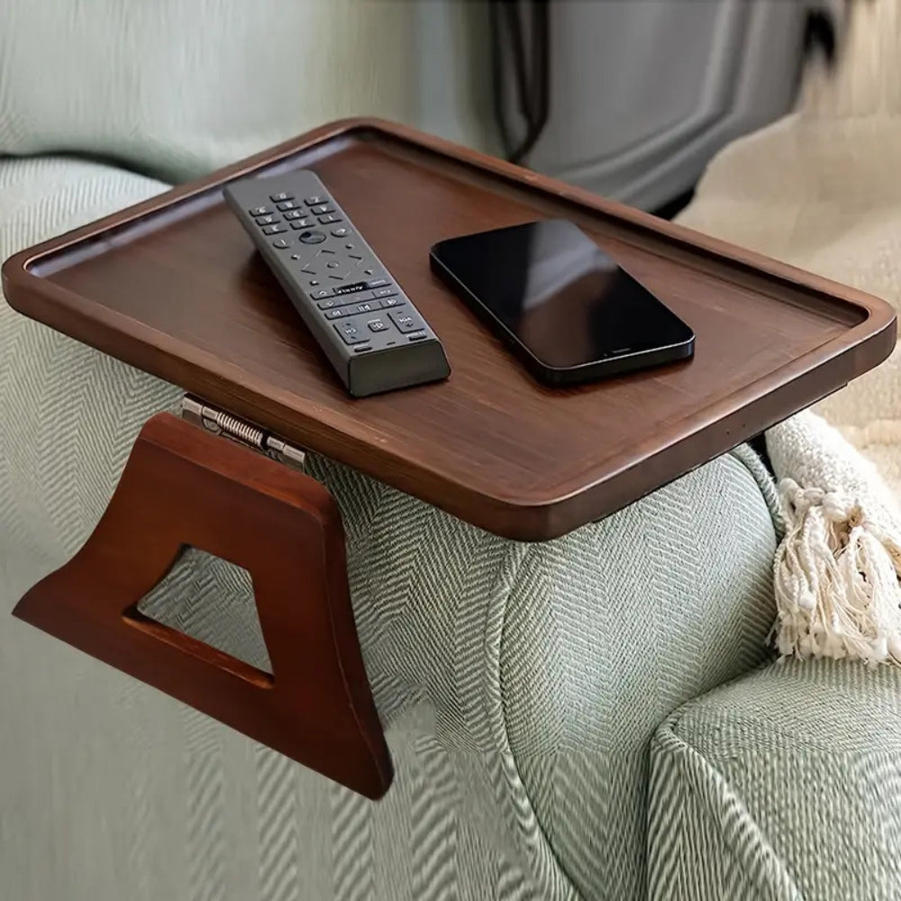 Wooden tray attached to a sofa with a remote control and phone on it