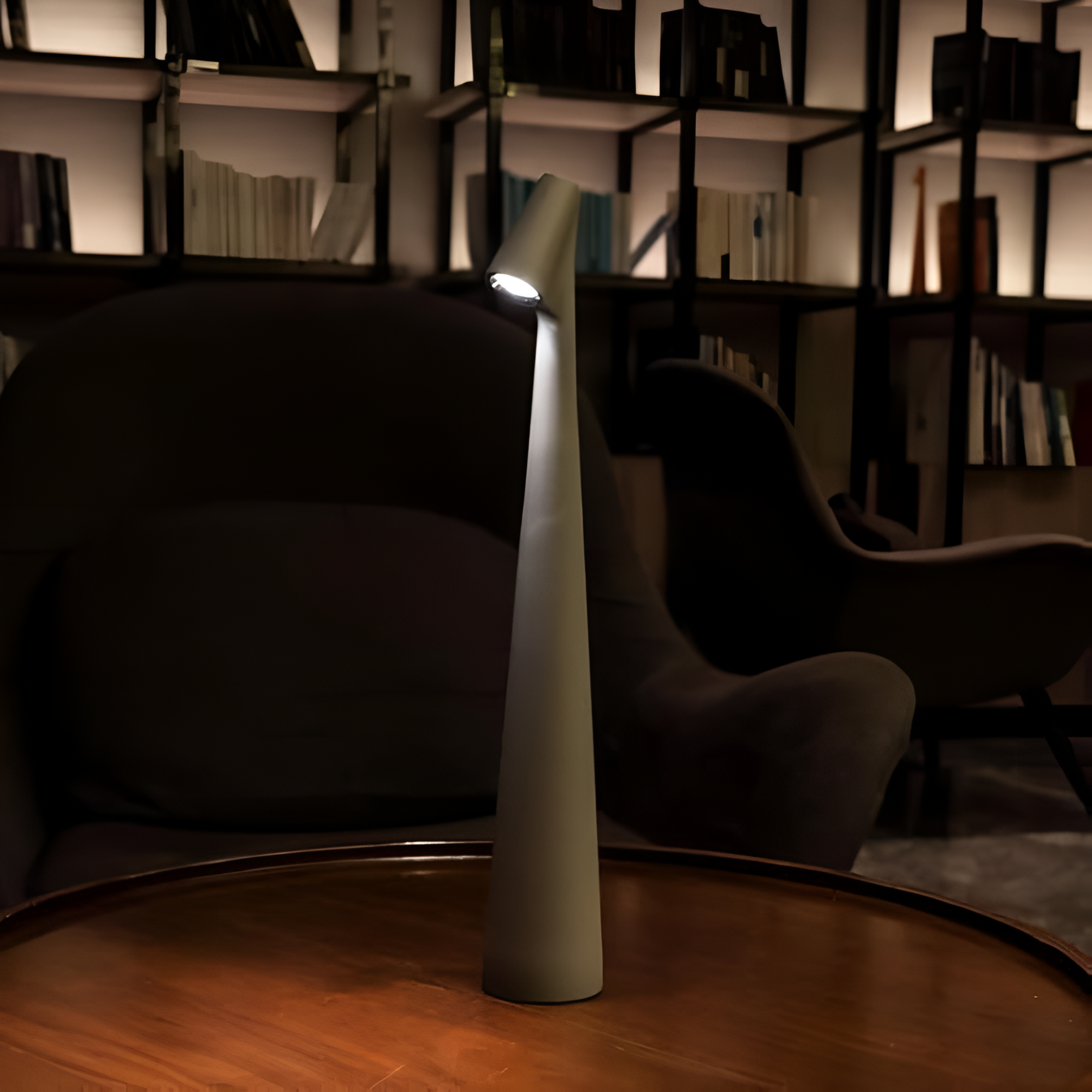 Modern floor lamp on a wooden floor with bookshelves in the background