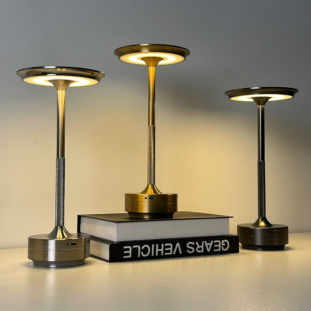 Three modern table lamps with a metallic finish on a neutral background