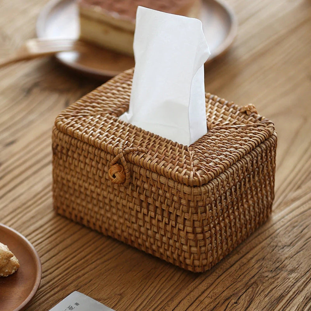 Woven tissue box on a wooden table with a tissue peeking out