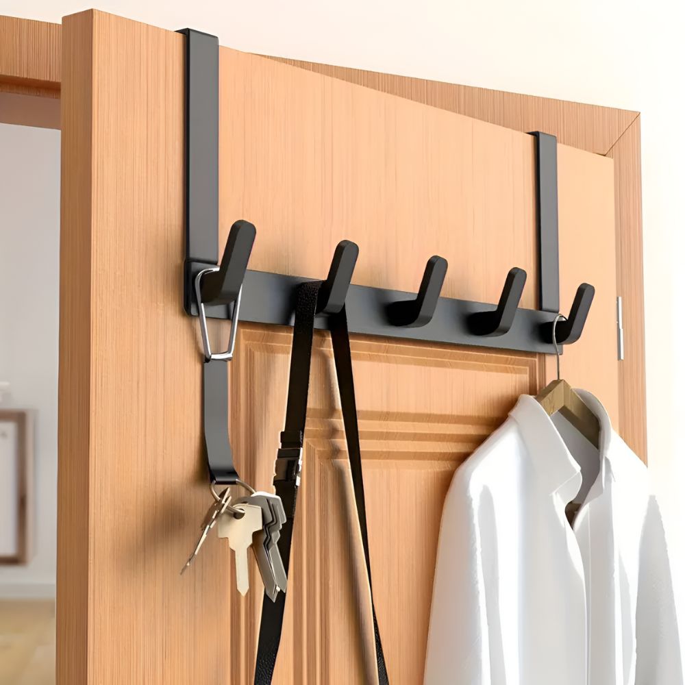 Over-the-door hook rack with keys and a coat on a wooden door.