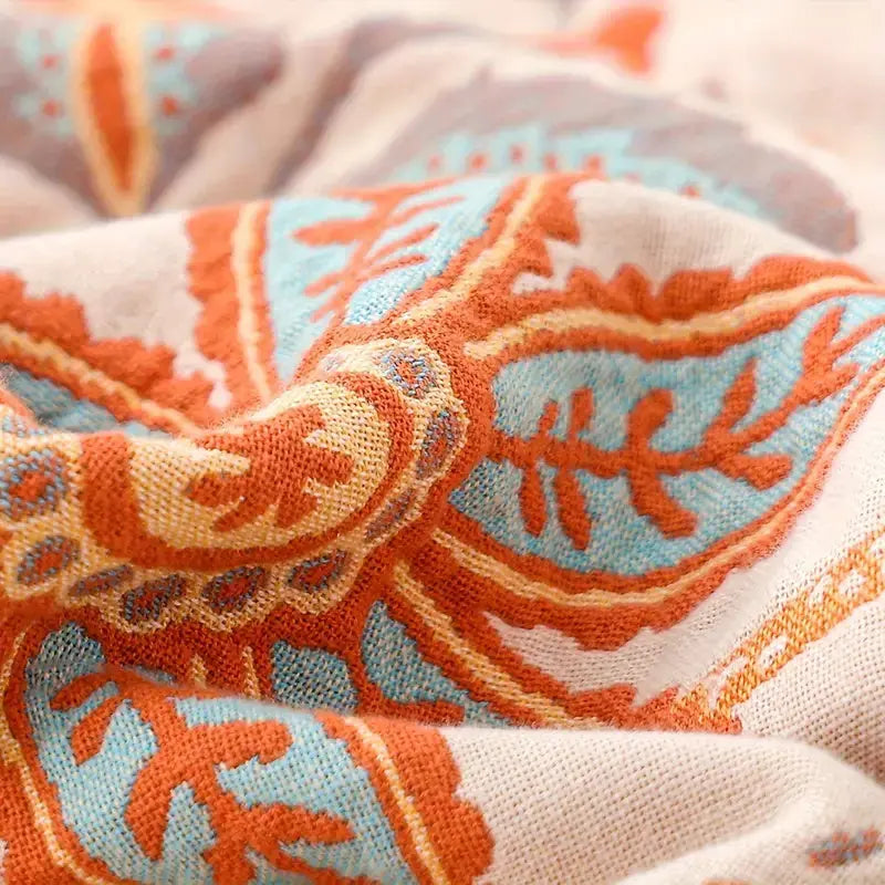Close-up of a fabric with orange and blue pattern on a neutral background