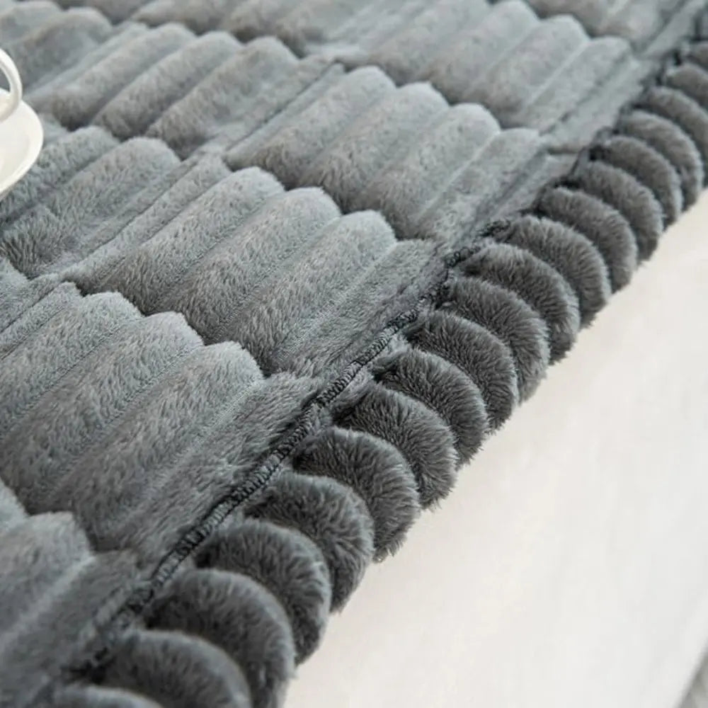 Close-up of a textured gray rug on a light-colored floor.