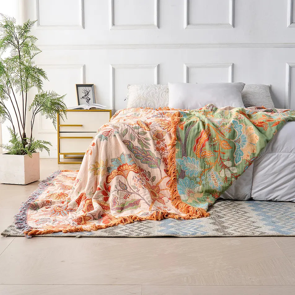 Colorful patterned blanket draped over a bed in a bedroom setting.