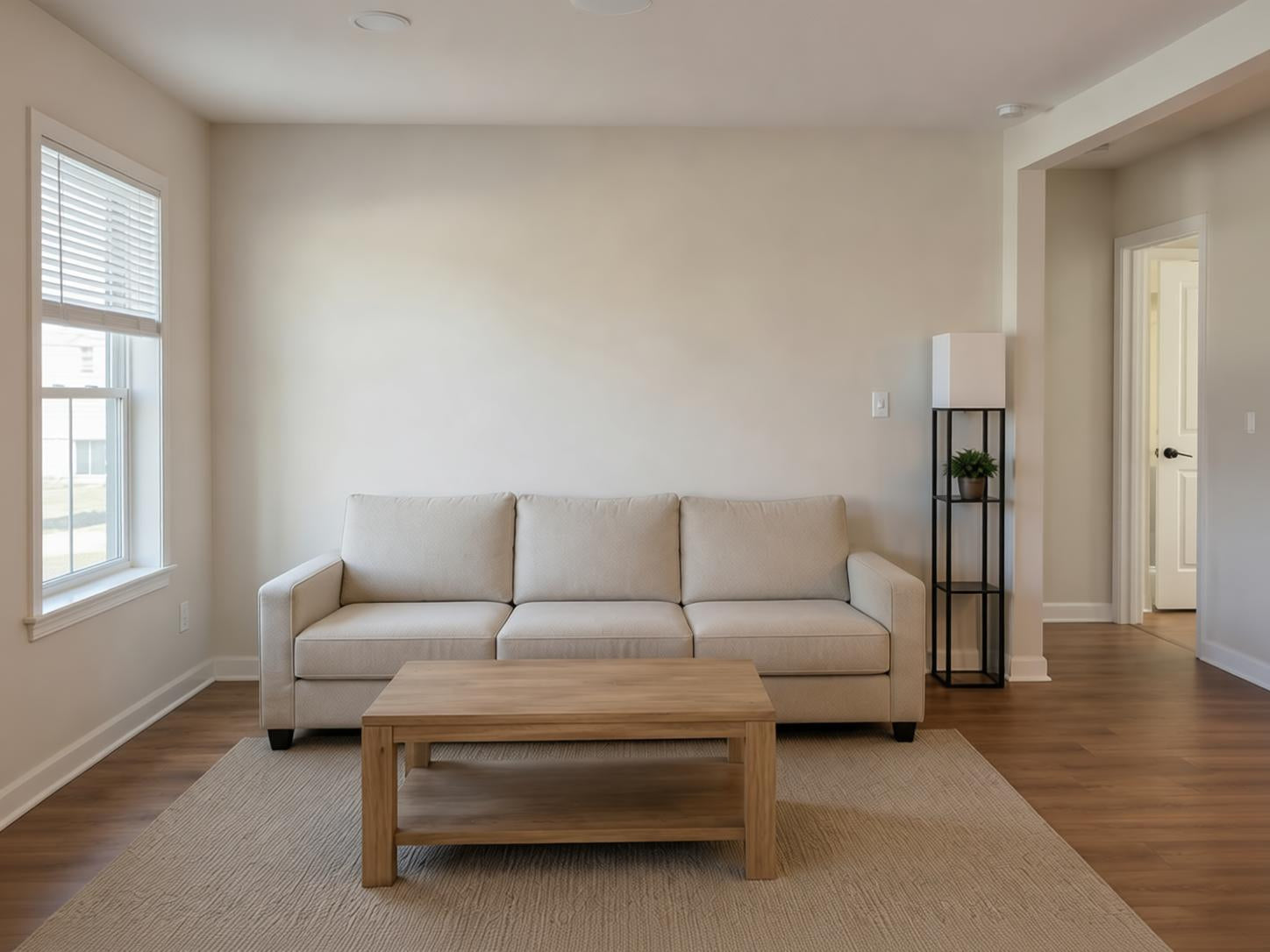 Living_room_with_a_beige_sectional_sofa_wooden_coffee_table_and_lamp