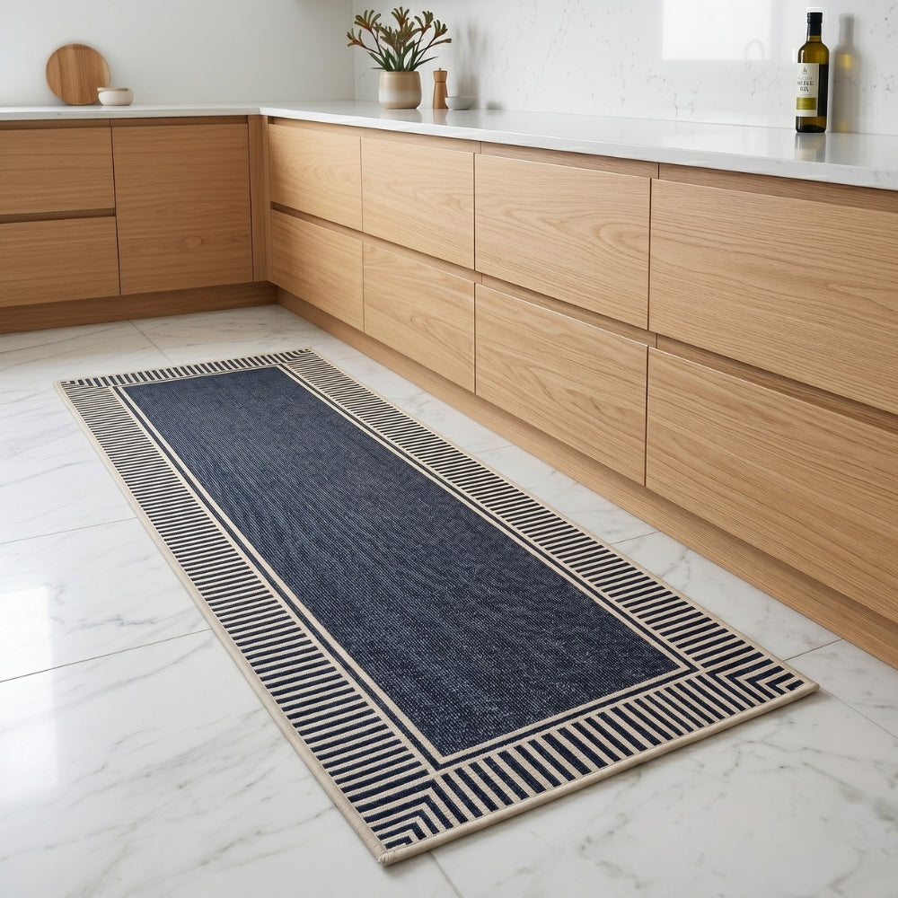 Long blue runner rug with beige border on a white tiled floor in a kitchen.