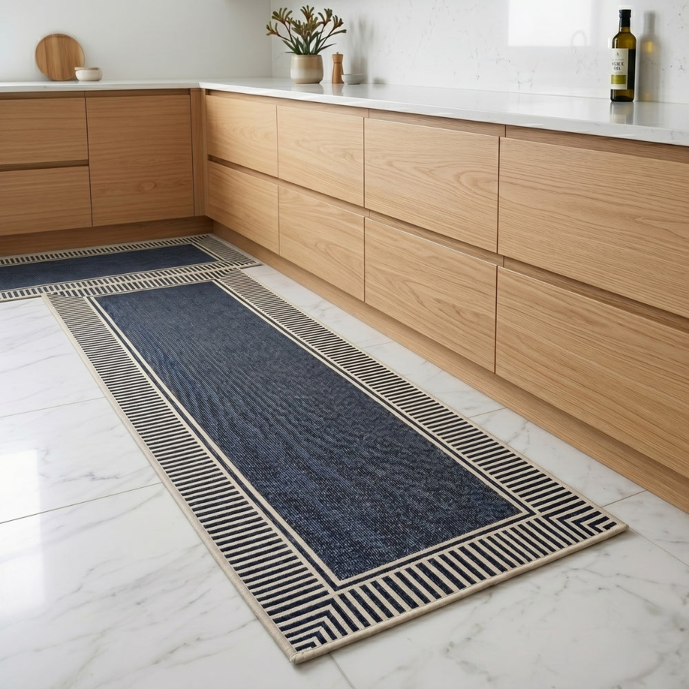 Long blue runner rug with beige border on a white tiled floor in a kitchen.