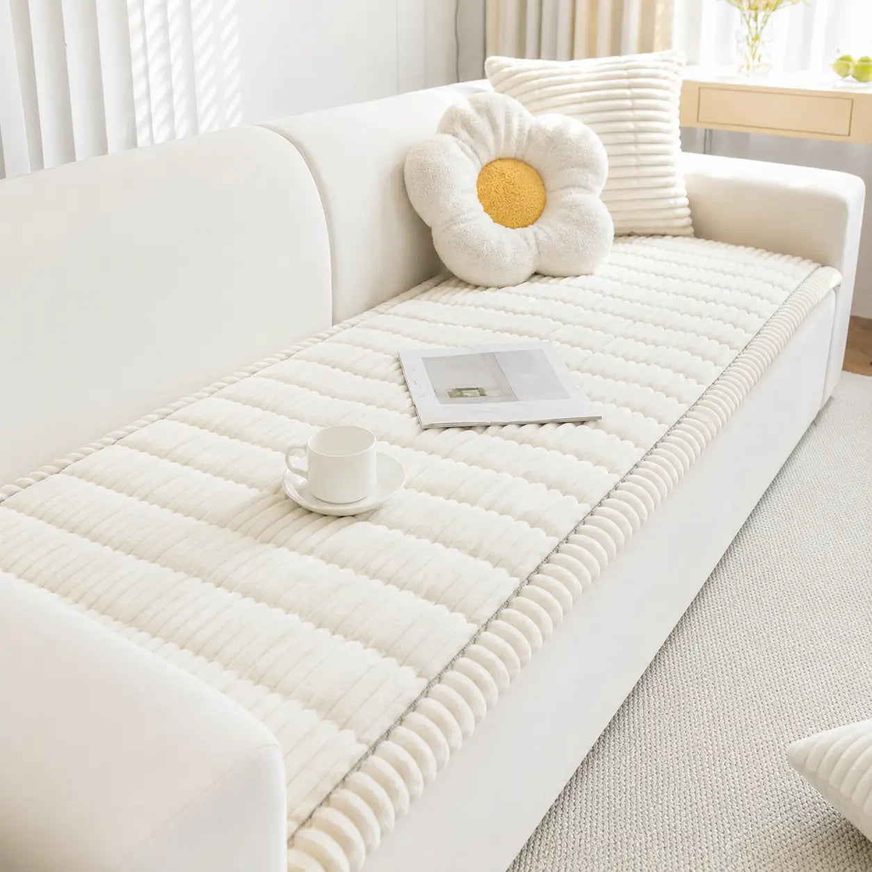 White sofa with a textured white cushion and a decorative pillow in a bright room.